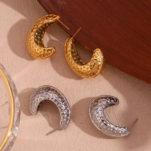 Vue détaillée des boucles d'oreilles en forme de C avec texture martelée dorée et argentée