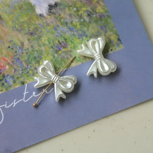 Macro detail of pearlescent butterfly DIY charms with gold pins on an artistic card