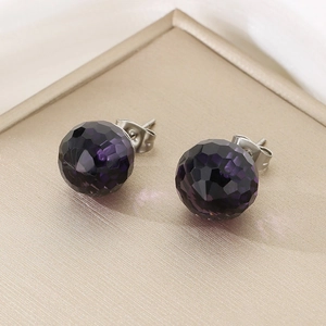 Macro shot of dark purple faceted crystal stud earrings with stainless steel pins