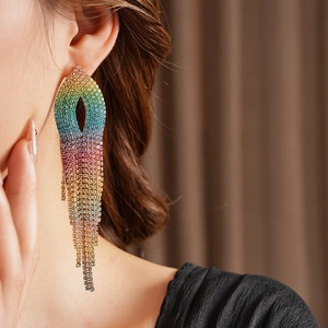 Detailed close-up of rainbow gradient tassel earrings with leaf-shaped rhinestone inlay