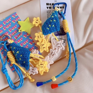 Close-up of handmade crochet blue tree and star bag charm with yellow smiley face beads
