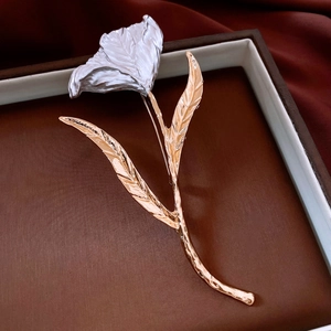 Détail de la broche tulipe aux pétales argentés et tige dorée dans son coffret