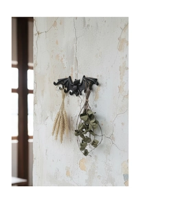 Detalle de un gancho de pared con forma de murciélago de hierro fundido negro estilo gótico