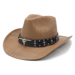 Brown woven straw cowboy hat with metallic bull skull leather band on white background