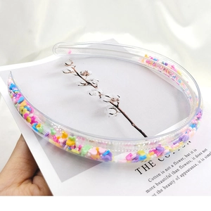 Macro detail of clear PVC headband filled with colorful heart and star shaped sequins