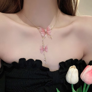 Detail of pink tulle butterfly necklace with tassels and faux pearls on model