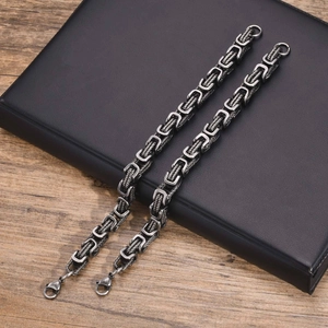 Detailed view of stainless steel Byzantine chain bracelet with lobster clasp on leather