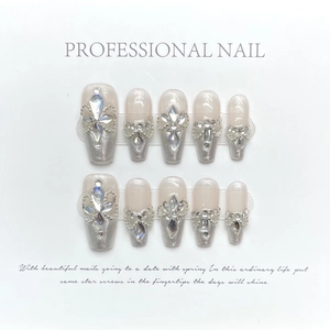 Aurora pink press-on nails set with luxury rhinestones and pearls on white card