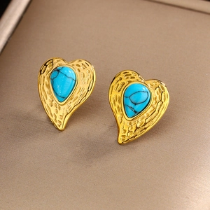 Close-up of vintage heart earrings with turquoise stones in gold textured setting