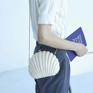 Chic shell-shaped acrylic clutch with gold chain strap in creamy white finish