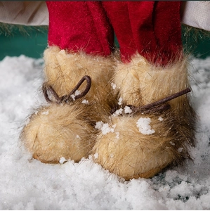Detail of Santa Claus figurine boots in light brown faux fur with brown lacing and red pants