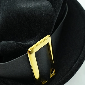 Detail of wool felt top hat featuring black leather band and gold rectangular buckle