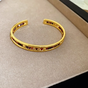 Détails d'un bracelet manchette doré bohème orné de perles colorées et motifs cœur