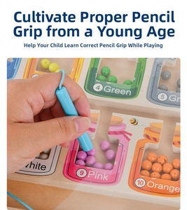 Detailed macro of a child using the magnetic pen to sort colored beads in the wooden maze