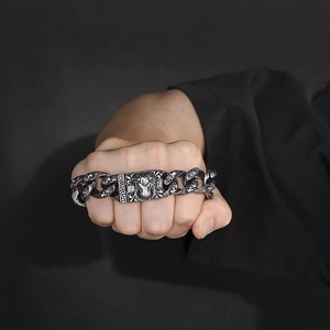 Close-up of vintage lion head bracelet on fist showing detailed metal relief and chain