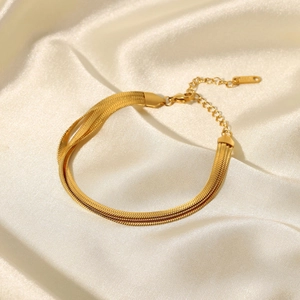 Vue détaillée du bracelet multicouche en maille serpent plaqué or 18K sur soie beige