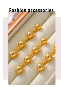 Detail of triple gold-plated teardrop tassel earrings with a high-polished mirror finish