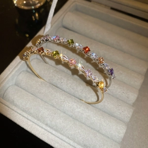 Detailed macro view of gold and silver star bangles with colorful zircon stones