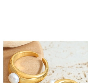Détail d'une bague nouée plaquée or 18 carats avec perle blanche sur pierre texturée