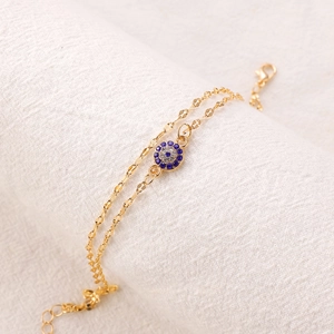 Vintage golden double-layered anklet with blue evil eye pendant and crystal accents