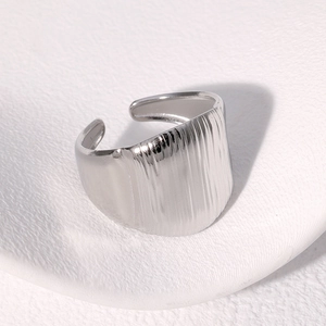 Macro detail of silver open ring showing vertical pleated texture and metallic finish