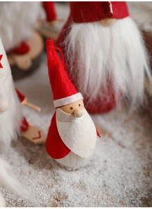 Detailed view of plush Christmas gnome ornaments set in a warm snowy holiday scene