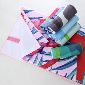 Detail of quick-dry beach towel showing various printed patterns and elastic storage strap