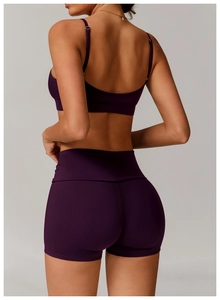 Back view of deep purple criss-cross yoga sports bra and high-waist fitness shorts