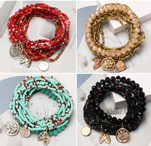 Detail of bohemian multilayer beaded bracelets with Tree of Life charms in four colors