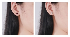 Detail view of 925 silver stud earrings with red and white zircon in a four-claw setting