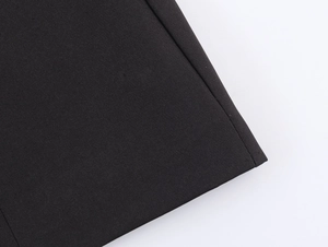 Detailed close-up showing the premium woven fabric and precision stitching of the black blazer