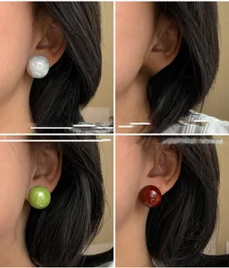 Vue détaillée de boucles d'oreilles boules 12mm en quatre couleurs portées à l'oreille