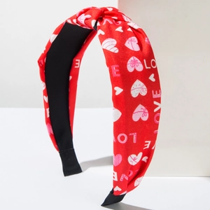 Red knotted headband with heart prints and LOVE text on white minimalist background