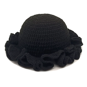 Detailed view of black crochet knit hat featuring retro ruffled wavy brim texture
