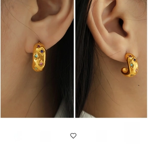 Detailed view of chunky C-shaped gold hoop earrings featuring multi-colored rhinestones
