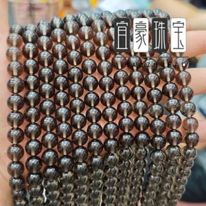 Detailed view of hand-held natural smoky quartz round beads for DIY jewelry making
