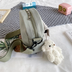 Sac à bandoulière en toile vert-gris avec pendentif ours blanc et large bandoulière