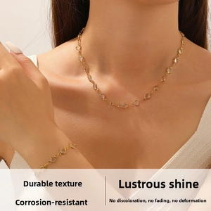 Close-up of gold-plated chain set with transparent crystals on female model