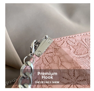 Detail of pink floral embroidery and silver metal chain hook on a fashion handbag