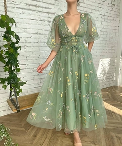 Detail of sage green tulle evening dress with floral embroidery and corset lacing