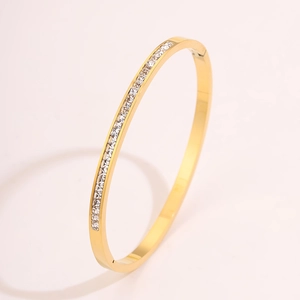 Detail of gold-plated stainless steel bracelet featuring paved cubic zirconia stones