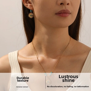 Detail of turquoise bead necklace and sun eye pendant set on a female model