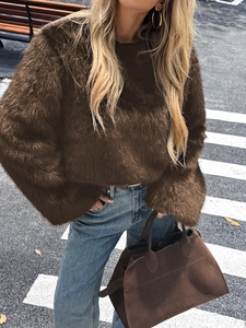 Dettaglio del pullover in peluche marrone scuro con vestibilità ampia e maniche lunghe