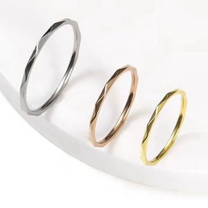 Three-piece ring set in silver, gold, and rose gold with faceted geometric design