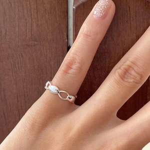 Macro shot of 925 sterling silver chain ring worn on finger with polished finish