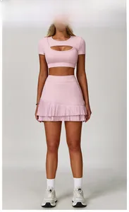 Detail of peach pink sports set featuring teardrop cutout crop top and pleated skirt