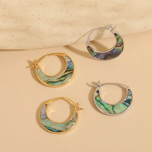 Orecchini a mezzaluna minimalisti placcati in oro 14K e argento su sfondo di pietra
