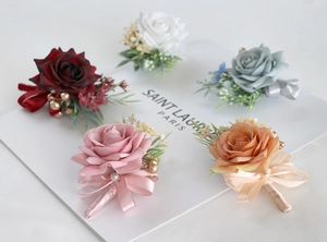 Detailed collection of five artificial rose wedding boutonnières with satin ribbons