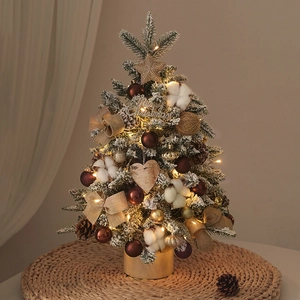 Mini lighted Christmas tree on woven mat with pinecones and golden ornaments for desk decor