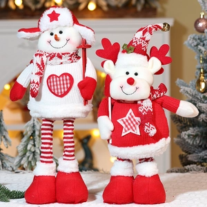Close-up of knit Christmas snowman and reindeer dolls with soft holiday light background